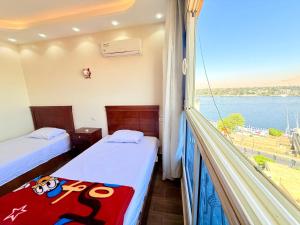 Zimmer mit 2 Betten und einem Balkon mit Aussicht in der Unterkunft Princes Palace in Luxor