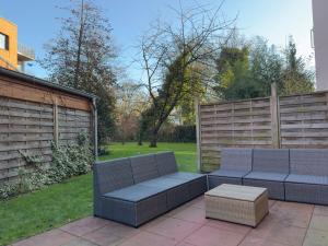 eine Terrasse mit zwei blauen Sofas und einem Tisch in der Unterkunft The Forest Green Residence with Garden & Tranquility in Oldenburg