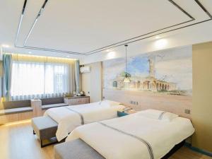 a bedroom with two beds and a painting on the wall at Urban Garden Hotel Chengyang District Government Liuting Airport in Qingdao