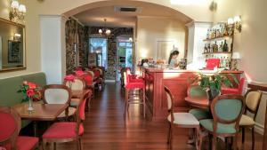 a restaurant with red chairs and a bar at Hotel Aktaion Syros in Ermoupoli