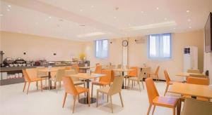 a dining room with tables and chairs and a kitchen at City Comfort Inn Liuzhou Longtan Park Ma'anshan Baiyun in Liuzhou