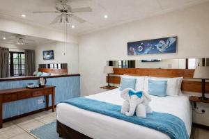 a bedroom with a bed with a stuffed elephant on it at Lodge At The Link in Kempton Park +67 photos