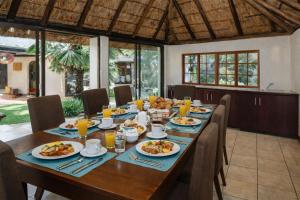 a dining room with a table with food on it at Lodge At The Link in Kempton Park