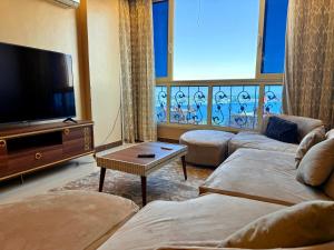 ein Wohnzimmer mit zwei Sofas und einem Flachbildfernseher in der Unterkunft Princes Palace in Luxor