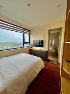 een slaapkamer met een groot wit bed en een groot raam bij Noric homestay in Hue