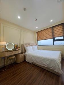 een slaapkamer met een bed en een bureau met een spiegel bij Noric homestay in Hue