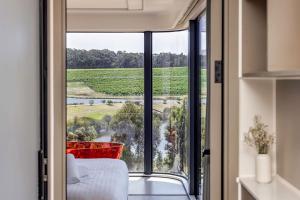 een kamer met een raam met uitzicht op een wijngaard bij Aravina Escapes in Yallingup Siding