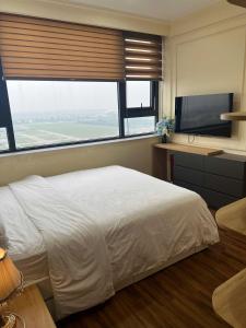 een slaapkamer met een groot bed en een flatscreen-tv bij Noric homestay in Hue +23 foto's
