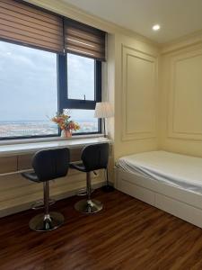 een slaapkamer met 2 stoelen, een bed en een raam bij Noric homestay in Hue