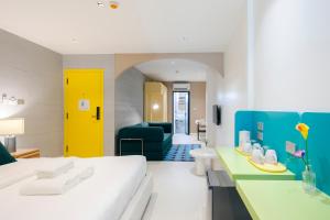 una camera d'albergo con un letto e una porta gialla di Bembis Hotel Charoenakorn 10 a Chinatown Altre 119 foto