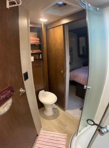 ein kleines Badezimmer mit Toilette und ein Schlafzimmer in der Unterkunft Cozy camper in Dunnellon