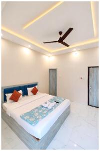 een slaapkamer met een bed met een plafondventilator bij Vrinda Home-Stay Near Vishwanath Temple - Free Wifi and Free Parking Facilities # Free Wifi Facilities # Fully Air conditioning Luxuary Room - Top Rated Hotel In Varanasi in Varanasi +14 foto's