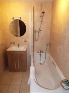 a bathroom with a bath tub and a sink at The Stableyard in Bedford