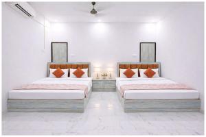 twee bedden in een kamer met witte muren bij Vrinda Home-Stay Near Vishwanath Temple - Free Wifi and Free Parking Facilities # Free Wifi Facilities # Fully Air conditioning Luxuary Room - Top Rated Hotel In Varanasi in Varanasi