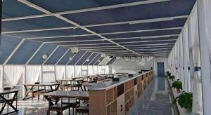 a restaurant with tables and chairs and blue ceilings at GreenTree Inn Express Liaoning Jinzhou Bijia Mountain in Dandong +29 photos