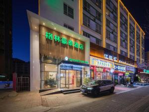 a car parked in front of a building at night at GreenTree Inn Luoyang Railway Station Wangfujing Wangcheng Park in Luoyang