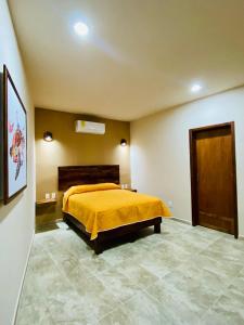 ein Schlafzimmer mit einem Bett mit gelber Tagesdecke in der Unterkunft Hotel Santa Cruz Mazunte in Mazunte + 13 Fotos