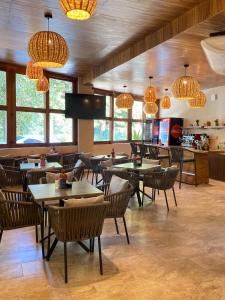 ein Restaurant mit Tischen, Stühlen und Kronleuchtern in der Unterkunft Hotel Santa Cruz Mazunte in Mazunte
