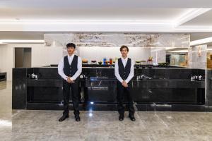 two men in suits standing in front of a counter at Marquis Hotel in Ban Bang Toei (1) +52 photos