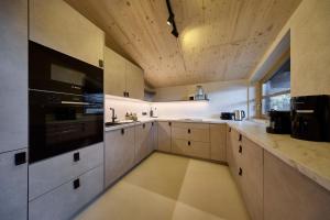 a large kitchen with white cabinets and a large appliance at fuchs am meer in Mitterhofen +19 photos