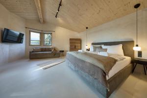 a bedroom with a large bed and a couch at fuchs am meer in Mitterhofen