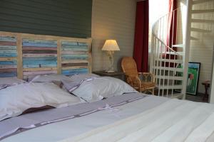 a bedroom with a large bed with a wooden headboard at La Villa Florida in Dieppe