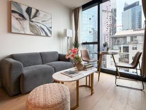 een woonkamer met een bank en een tafel bij Aspire Boutique Condo Melbourne CBD in Melbourne