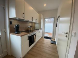 a kitchen with a sink and a stove at Petkumer Deichkoje in Emden