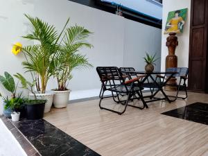 a room with chairs and a table and plants at The Picture House M'Pai Bay in Kaôh Kon