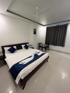 a bedroom with a large bed with blue and white sheets at Hotel Giriraj Palace in Jaipur