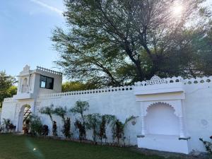 una cerca blanca frente a un edificio en The Ummed Palace, en Udaipur