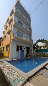 a building with a swimming pool in front of a building at Dream stay villaa in Pondicherry