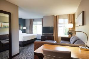 a hotel room with a bed and a living room at Hyatt House Seattle Bellevue in Bellevue