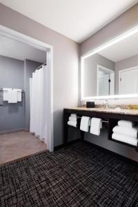 a bathroom with a sink and a mirror at Hyatt House Seattle Bellevue in Bellevue