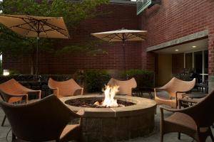 - un foyer extérieur sur une terrasse avec des chaises et des parasols dans l'établissement Hyatt House Seattle Bellevue, à Bellevue
