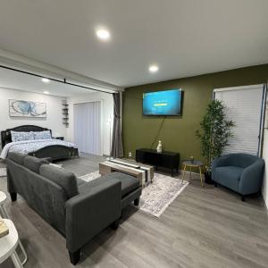 un soggiorno con letto e TV a parete di 2 DT Dallas l FIFA WORLD CUP READY l 5 Min from Love Field a Dallas