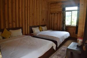 ein Schlafzimmer mit zwei Betten und einem Fenster in der Unterkunft The Kalp in Jāmb