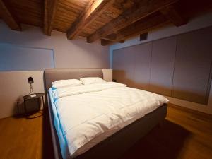 une chambre avec un grand lit avec des draps blancs dans l'établissement LAKE-SIDE Säntisblick, à Romanshorn