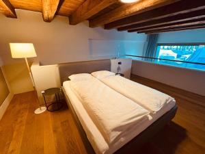 - une chambre avec un lit dans un dortoir doté d'une lampe dans l'établissement LAKE-SIDE Säntisblick, à Romanshorn