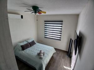 ein Schlafzimmer mit Bett und Deckenventilator in der Unterkunft Vivienda completa 2 plantas, y privada con acceso controlado in Hermosillo