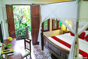 a bedroom with a bed with a canopy at Shewe Wana Boutique Hotel in Chiang Mai +35 photos