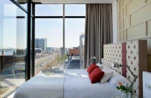 a bedroom with a large white bed with red pillows at Eric Vökel Boutique Apartments - Amsterdam Suites in Amsterdam