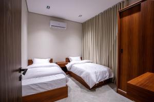 ein Hotelzimmer mit 2 Betten und einer Tür in der Unterkunft our residence in Riad