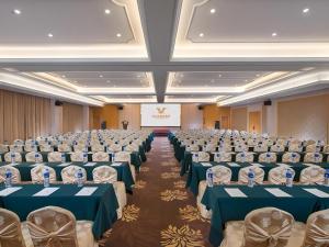 a large room with rows of chairs with blue tables at Vienna Hotel Guangdong Foshan Wenhua North Road in Nanhai
