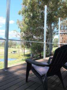 a bench on a deck with a view of a field at Little Birdy in Tawonga