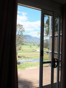 a door to a balcony with a view of a lake at Little Birdy in Tawonga