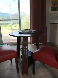 een tafel en twee stoelen in een kamer met een raam bij Little Birdy in Tawonga