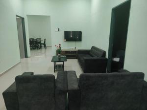 un salon avec des canapés et une télévision à écran plat dans l'établissement Seri Mersing Villa, à Mersing