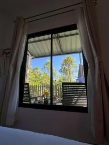 a bedroom window with a view of a balcony at Yada House Alina Cottage in Nai Yang Beach