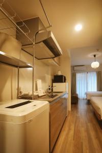 eine Küche mit Spüle und Herd im Zimmer in der Unterkunft DL Shinsaibashi in Osaka